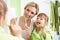 Mother and child brushing teeth in bathroom