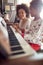 Mother with child on Christmas play music on piano. concept of h