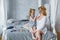 Mother and child do cosmetic procedures together. Happy family mother and baby daughter make a face mask in the bedroom. Concept