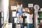 Mother and child girl hang their drawings on wall