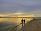 mother and child hand in hand, under the sunset, the sky is very beautiful, the coast of lombok Indonesia