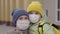 Mother and child hug in medical masks, time of pandemic, school life kid with a backpack, mom meets kid daughter from