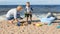 Mother and child play with sand on the ocean shore.