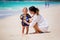 Mother and child playing at tropical beach. Family sea summer vacation. Mom and kid, toddler boy, play in the water. Ocean and