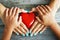 Mother and child pure love concept, with red hearth in their hands on rustic wooden table