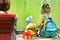 Mother and child relaxing in the park by the pond. They sitting on a sidewalk by the lake and looking on water