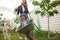 Mother and child ride a garden cart having fun in backyard garden