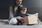 Mother and child sitting on bed and unwrapping package. Family shopping online with quick delivery of goods to your front door