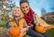 Mother and child sitting on haystack with pumpkins