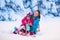 Mother and child sledding in a snowy park