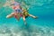 Mother with child swim underwater with fun in sea