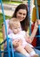 Mother and a child swinging in a playground