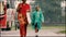 Mother and child walks down the street with an umbrella during a rainy day on a water-logged road as a heavy monsoon downpour hits