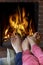 Mother And Child Warming Bare Feet By Fire