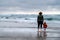 Mother and Child watch waves under storm clouds