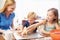 Mother And Children Baking Cookies Together At Home