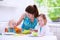 Mother and children cooking in a white kitchen