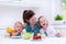 Mother and children cooking in a white kitchen