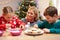 Mother And Children Decorating Christmas Cookies Together