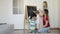 Mother with children draw chalk on a blackboard.