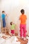 Mother with children remove old wallpapers