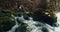 Mother with children rest on mountain river during summer hike journey