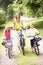 Mother and children riding bikes in countryside