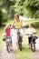 Mother and children riding bikes in countryside