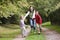 Mother and children running along woodland path