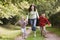 Mother and children running along woodland path