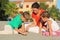 Mother with children sit on beach and draw
