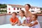 Mother and children sit in day-time on balcony