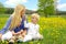 Mother and Children Sitting Outside in Dandelion Flower Meadow
