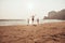 Mother and children skipping on a sandy beach during vacation