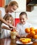 Mother with children squeezed orange juice