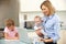 Mother with children using laptop in kitchen