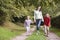 Mother and children walking along woodland path