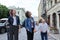 Mother and children walking together on city street and looking up