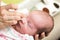 Mother cleaning eyes of a newborn baby