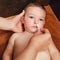 A mother cleans her nose with a cotton swab to a happy toddler baby b