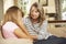 Mother Comforting Teenage Daughter Sitting On Sofa At Home