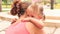 mother comforts crying little daughter with hairtails in park