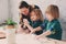 Mother cooking with kids in kitchen. Toddler siblings baking together and playing with pastry at home