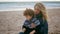 Mother cover blanket kid on cold beach picnic closeup. Unconditional parent love