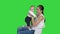 Mother and cute baby sitting on a chair on a Green Screen, Chroma Key.