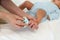 mother cutting baby\'s foot fingernails with nail scissors