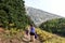 A mother and daugher hiking a beautiful trail above the treeline with a huge mountain in the background during a sunny fall day