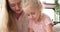 Mother with daughter assembling toy blocks at home