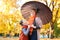 Mother and daughter are in autumn city park. Peoples are posing under umbrella. Children and parents are smiling, playing and havi