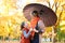 Mother and daughter are in autumn city park. Peoples are posing under umbrella. Children and parents are smiling, playing and havi